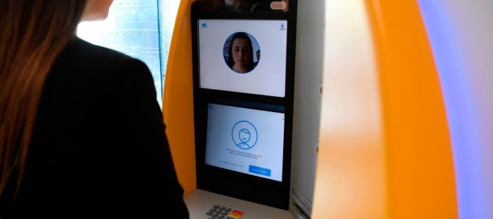 A woman uses an ATM with facial recognition technology during the presentation of the new service by CaixaBank